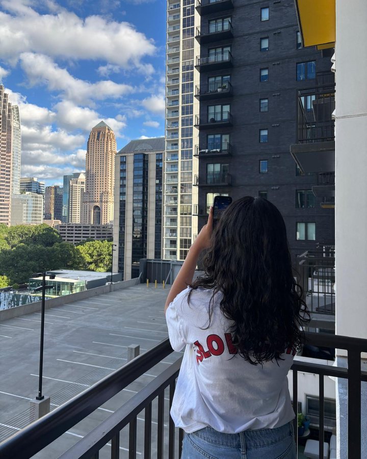 Simar photographing the Atlanta skyline from a balcony