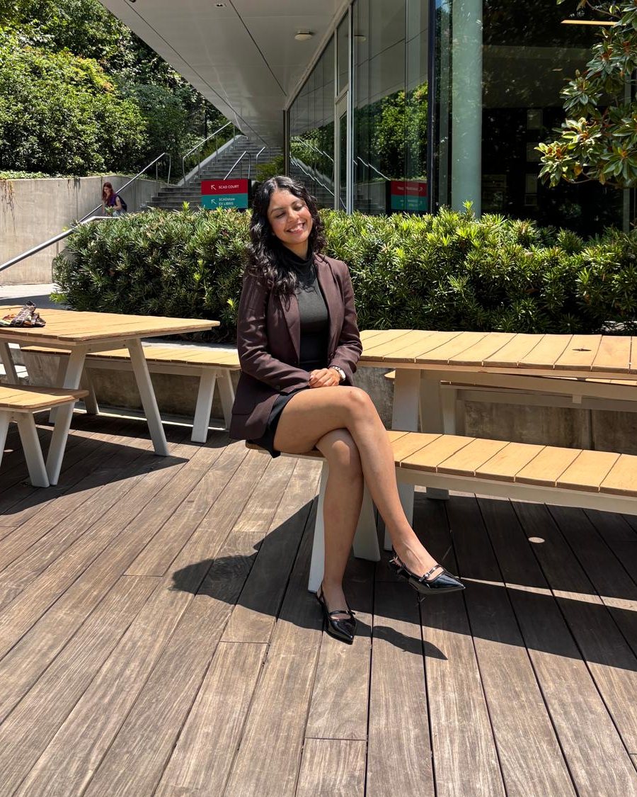 Simar in a brown blazer, sitting outside a SCAD Atlanta building